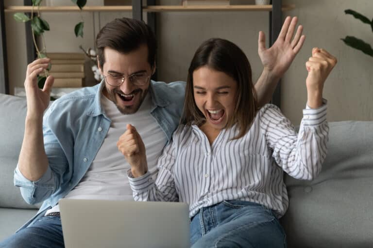 Euphoric couple cheerful male female read unbelievable Google bonus Digitalspot kod news on laptop